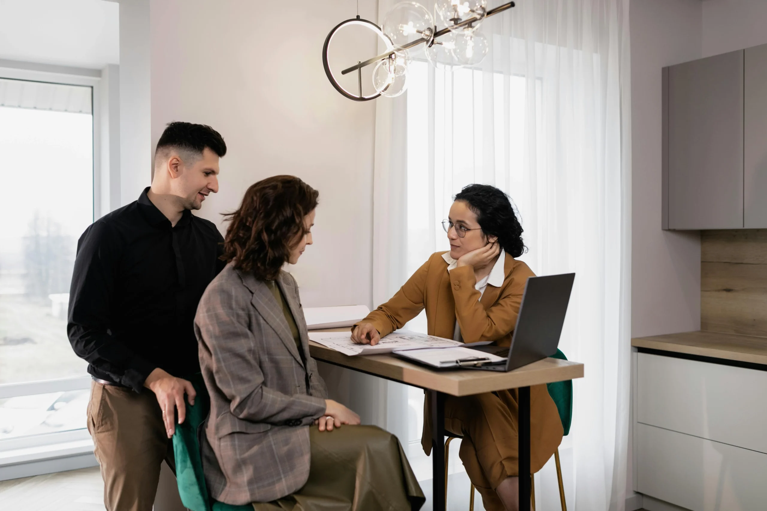 A couple consulting a real estate agent in a professional office setting, representing professional directory websites