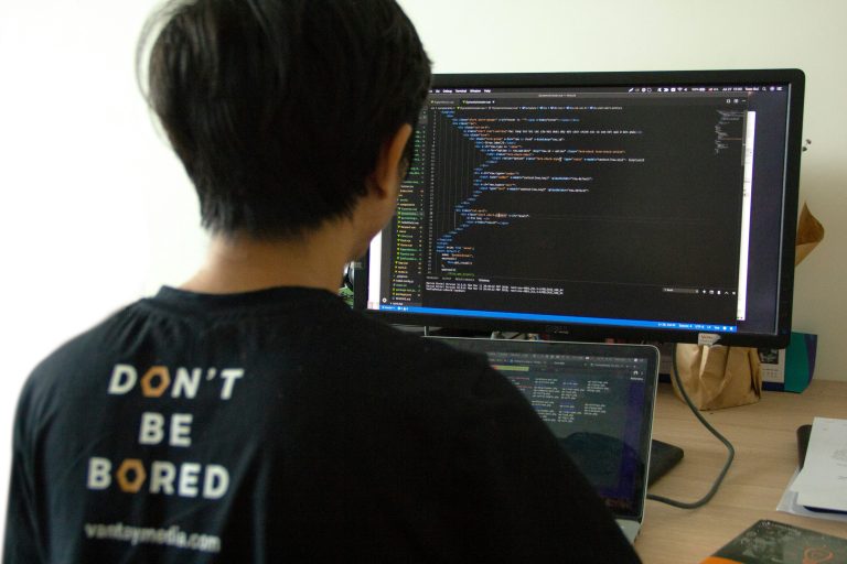 Developer working with code on multiple screens representing REST API development